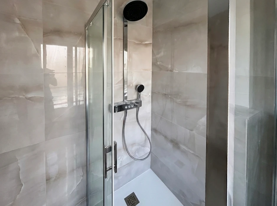 Salle de bain moderne avec double vasque encastrée sur meuble suspendu blanc laqué, robinets mitigeurs noirs mats, tiroirs à poignées noires