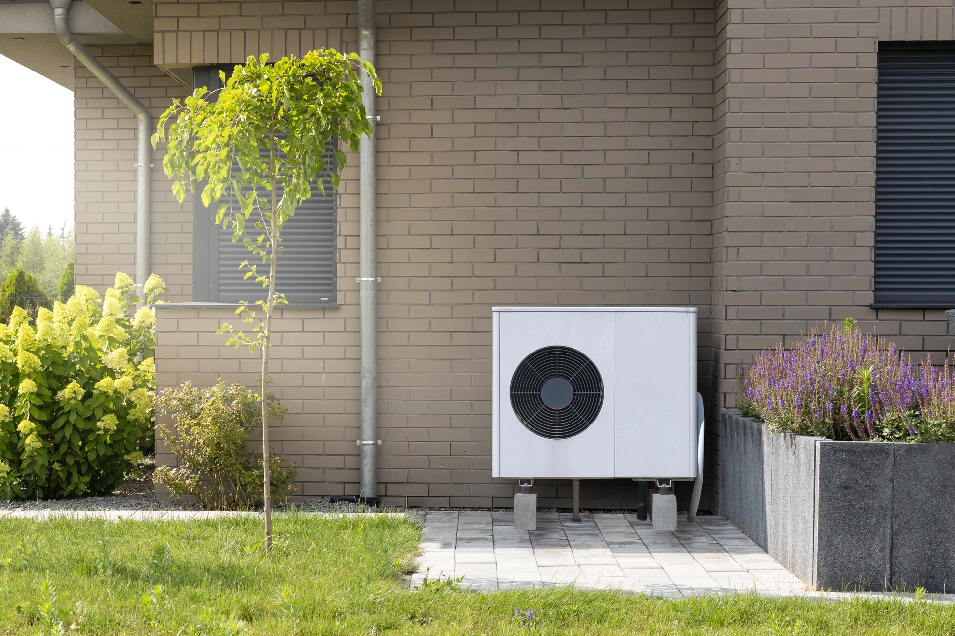 Technicien en plomberie travaillant sur un collecteur de chauffage au sol dans un local technique