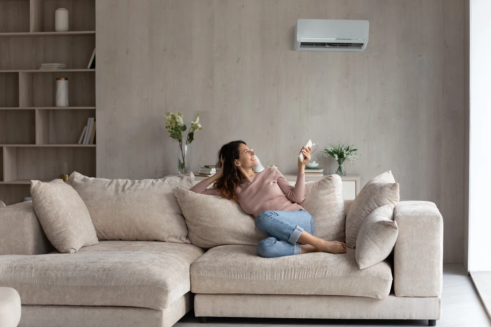 Extérieur résidentiel avec unité extérieure de climatisation installée contre un mur blanc