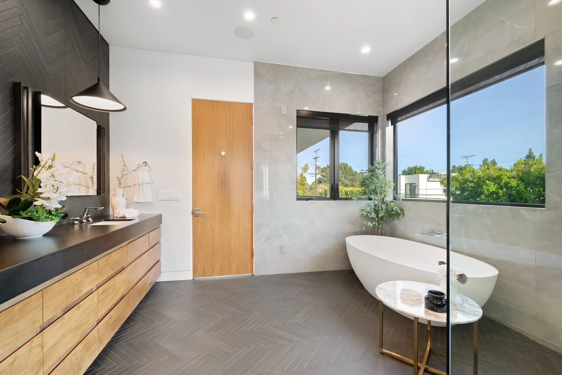 Salle de bain moderne avec douche à l'italienne vitrée, lavabo blanc suspendu et robinetterie chromée
